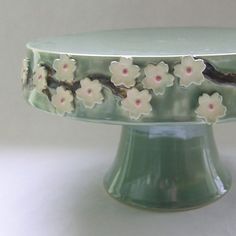 a green cake plate with white flowers on it