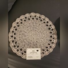 a crocheted doily is on display in a museum exhibit case with a price tag