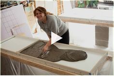 a woman is making a sculpture out of clay