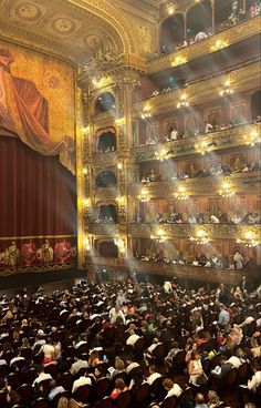 an auditorium filled with people sitting and standing