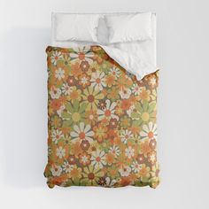 an orange and green flowered comforter with white pillows