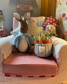 a stuffed rabbit sitting on top of a couch next to a basket filled with vegetables