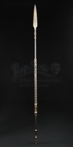 a large metal pole with an ornate design on the top and bottom, standing in front of a black background