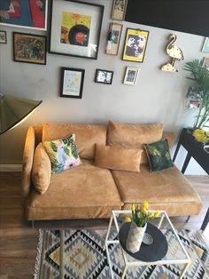 a living room filled with furniture and pictures on the wall