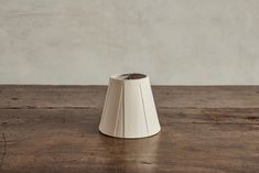 a white vase sitting on top of a wooden table