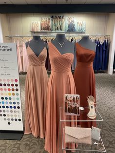 three bridesmaid dresses are on display in a clothing store, and there is a color guide for each dress