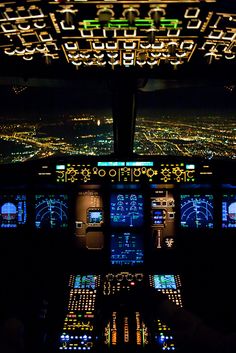 the cockpit of an airplane at night with illuminated lights on it's windows and dashboards