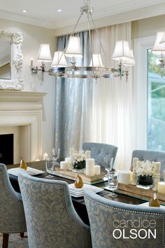 an elegant dining room with candles and flowers on the table in front of a fireplace