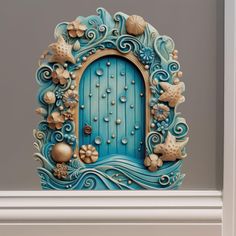 a blue door with shells and seashells on the front is shown in an ornate frame