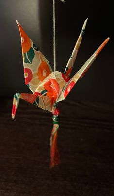 an origami bird hanging from a string