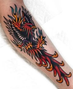 a tattoo with an eagle on it's arm and flames coming out of its wings