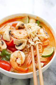 a bowl of shrimp noodle soup with chopsticks