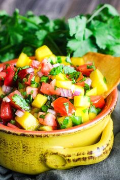 a yellow bowl filled with fruit and veggies