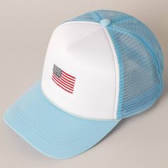 a blue and white trucker hat with an american flag embroidered on the front side