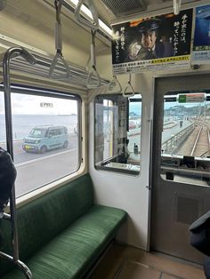 the inside of a train car with green seats and a bench in front of it