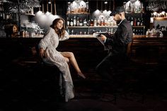 a man and woman sitting at a bar