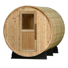 a wooden barrel sauna is shown with the door open and side opening to it