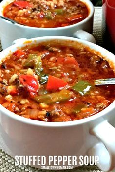 two white bowls filled with chili soup on top of a table next to a red pot