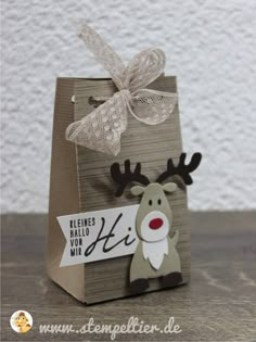 a small bag with a reindeer on it and a tag hanging from the front, sitting on a table