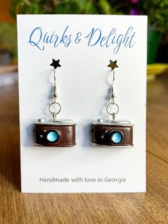 Hey photography lovers! Express yourself with these adorable retro camera earrings. Handmade with love using hypoallergenic hardware, these quirky earrings feature a brown resin camera charm with blue lens perfect for anyone passionate about photography or all things vintage. Plus, they are lightweight and comfortable to wear all day! Whether you're a shutterbug or just love quirky accessories, these earrings are the perfect way to showcase a creative spirit. *Hypoallergenic and nickel-free, saf Camera Earrings, Earrings Photography, Quirky Accessories, Camera Charm, Quirky Jewelry, Quirky Earrings, Blue Lens, Retro Camera, Photo Vintage