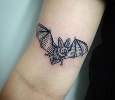 a small bat tattoo on the arm