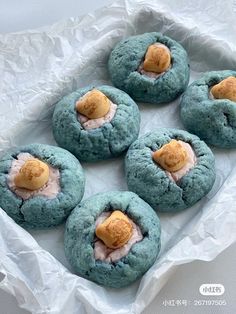 four blue cookies with peanut butter on top