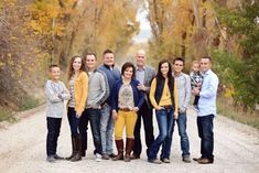 a group of people standing in the middle of a dirt road with trees behind them