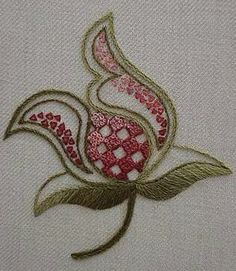 a close up of a flower on a piece of white fabric with pink and green accents