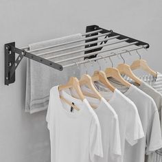 there is a rack with shirts hanging on the clothes hanger next to some t - shirts