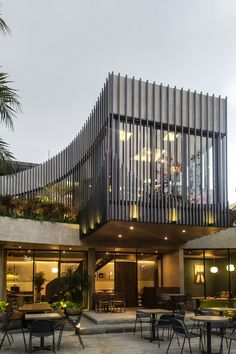 an outdoor dining area with tables and chairs next to a large metal structure on top of a building