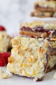 three pieces of dessert sitting on top of a white plate next to raspberries