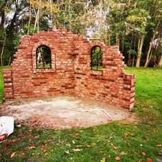 an old brick wall with two windows in it