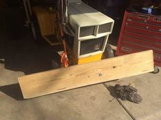 an air conditioner sitting on top of a piece of wood next to a toolbox