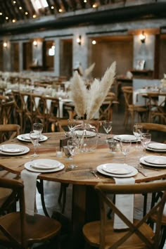 the tables are set with white plates and place settings for an elegant dinner or party