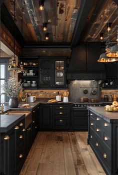 a kitchen with black cabinets and wooden floors is lit up by lights hanging from the ceiling