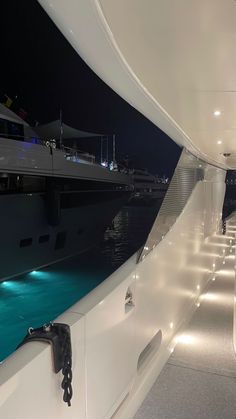 the interior of a boat at night with lights on and water in the foreground