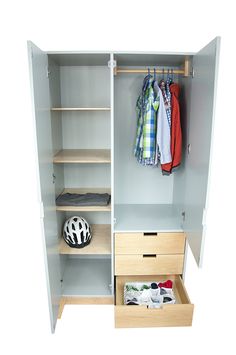 an open closet with clothes hanging on the shelves and a helmet sitting on top of it