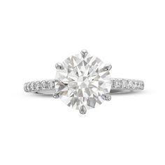 a round cut diamond ring with pave set diamonds on the shoulders and sidestones