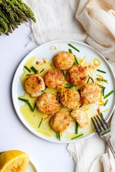 a white plate topped with scallops and green beans