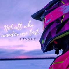 a person wearing a pink jacket and helmet looking out at the ocean with a quote written on it