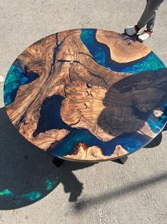 a skateboarder is standing on top of a wooden table with blue and brown paint