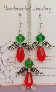 a pair of red and green earrings hanging from a silver chain