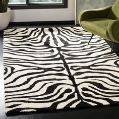 a black and white zebra print rug in a living room next to a green chair