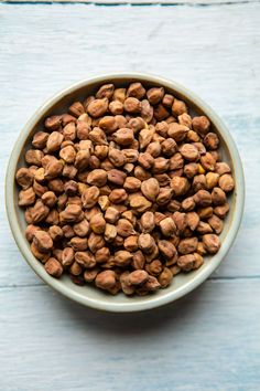 a bowl filled with nuts on top of a wooden table