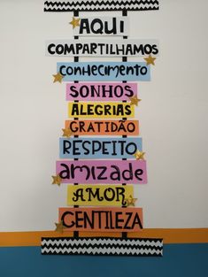 the words are written in different colors and sizes on a white wall with black and yellow stripes