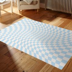 a blue and white checkered rug on the floor in front of a radiator