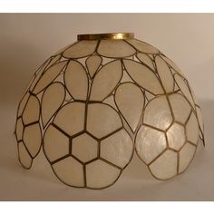 a lamp that is sitting on top of a white surface with gold trimmings