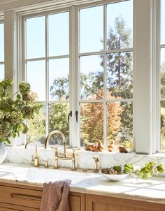 a kitchen with marble counter tops and large windows