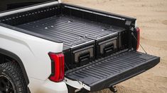 the truck is parked in the sand with its bed open