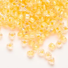 yellow seed beads are scattered on a white surface